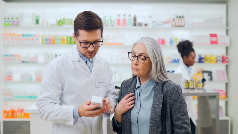 A mature woman filling a prescription with a pharmacist.