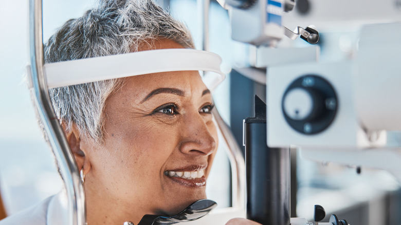 A mature woman having her eyes checked in an optometrist's office.