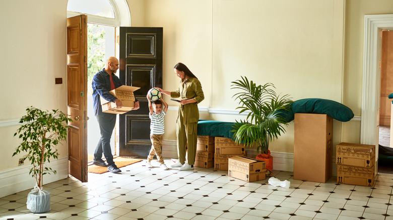 young family moving boxes into a new home