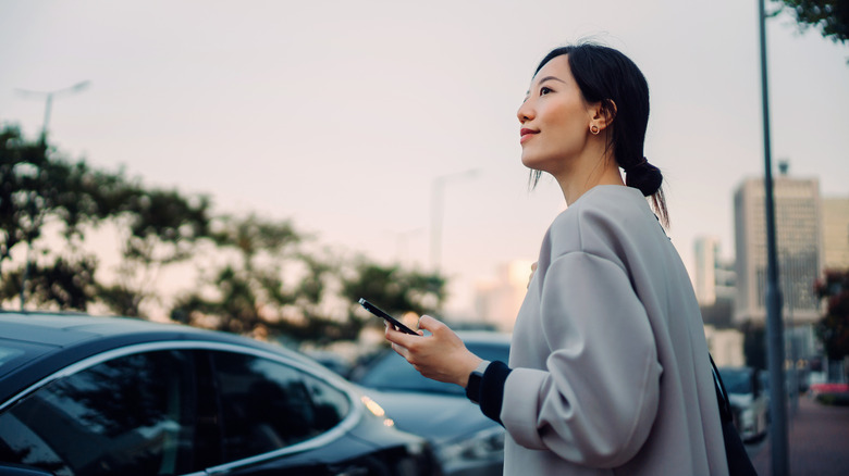Confident and professional young Asian businesswoman walking to her car,