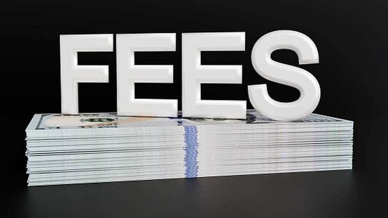The word "fees" on top of a stack of $100 bills