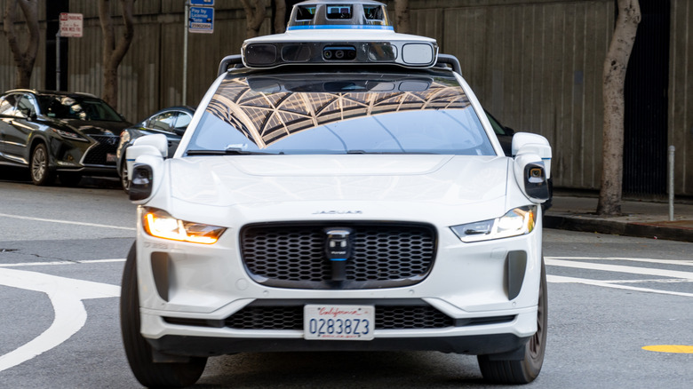 A white, self-driving Jaguar I-Pace SUV in San Francisco in May 2025.