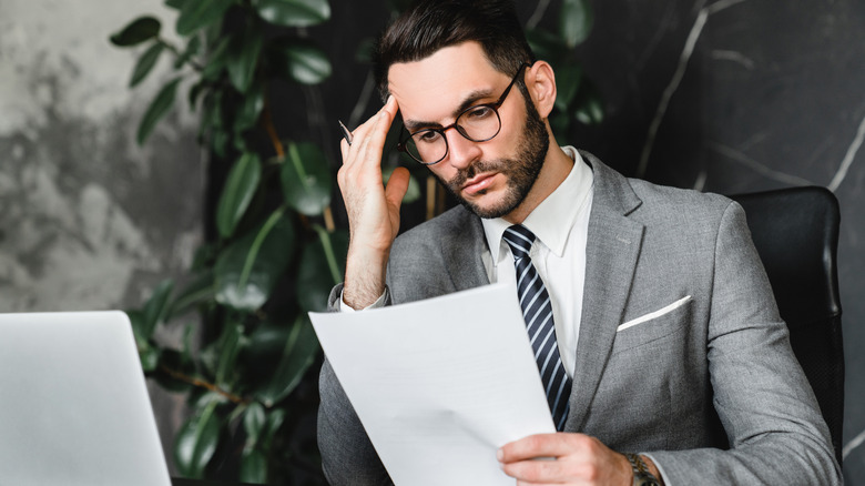 Man looking worried while studying a document