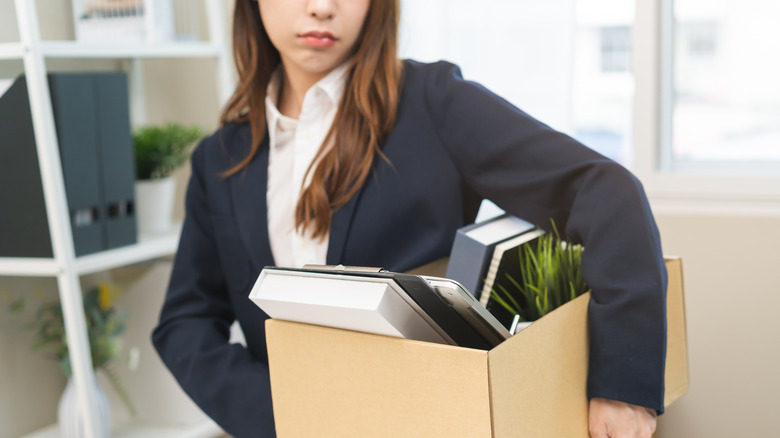 Woman carrying a box of belongings from her job