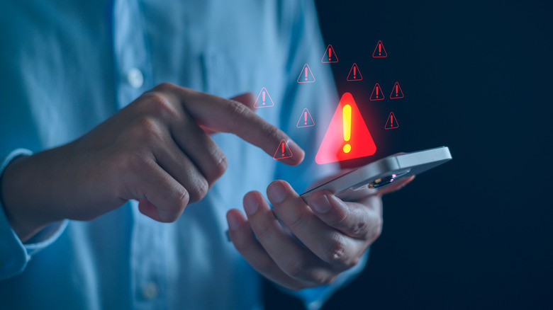 man looking at phone with a fraud alert image above