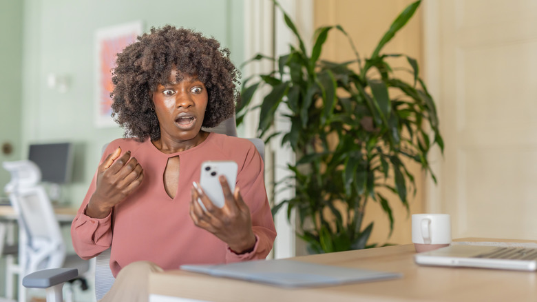 a woman surprised at information on her phone