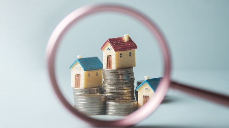 Houses sitting on stack of coins